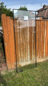British Standards glass pane resting on wooden fence