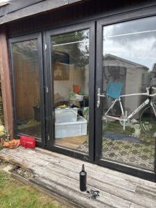 Door glass pane reflecting the skies outside while showing the inside of the property